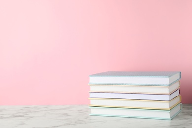 Photo of Stack of hardcover books on table against color background, space for text