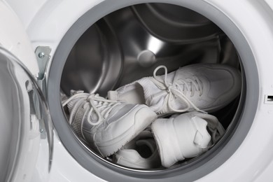 Stylish clean sneakers inside modern washing machine