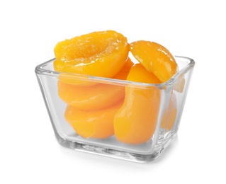 Bowl with halves of canned peaches on white background