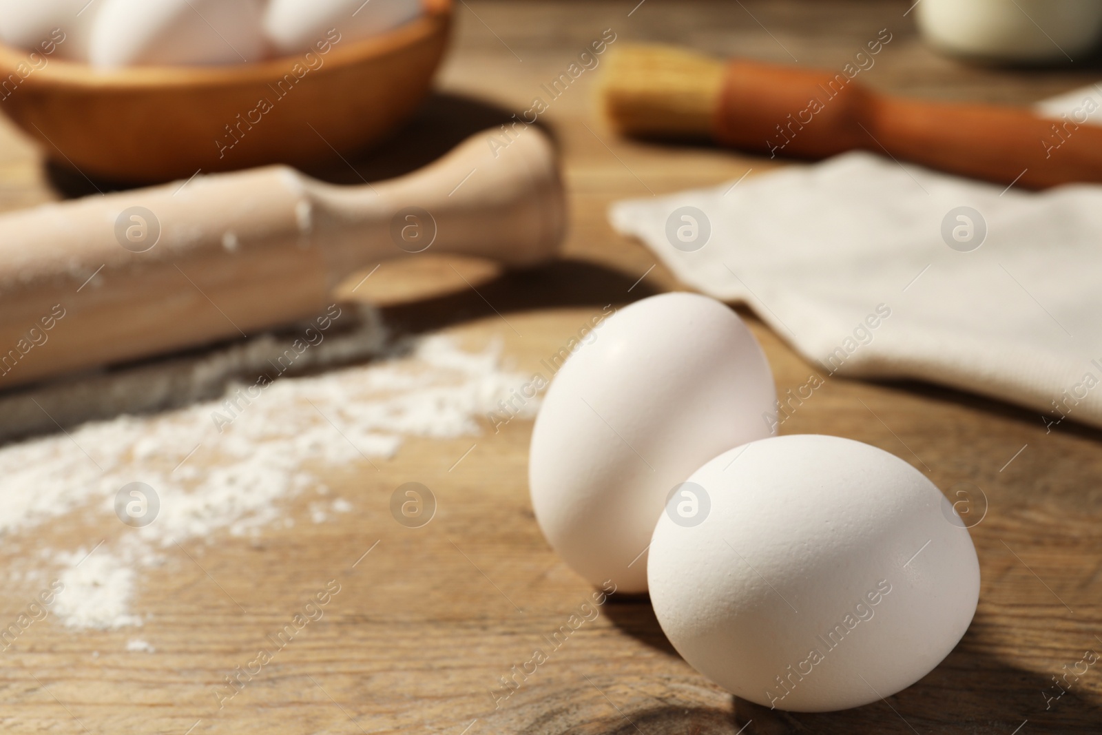 Photo of Two raw chicken eggs on wooden table in kitchen. Space for text