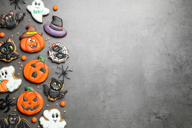 Photo of Tasty cookies and sweets for Halloween party on black table, flat lay. Space for text