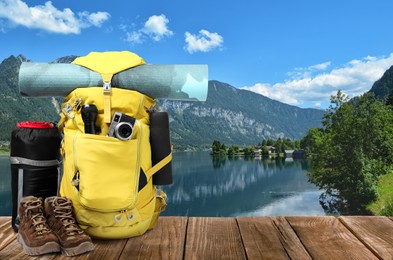 Image of Camping equipment for tourist on wooden surface and beautiful view of mountain landscape