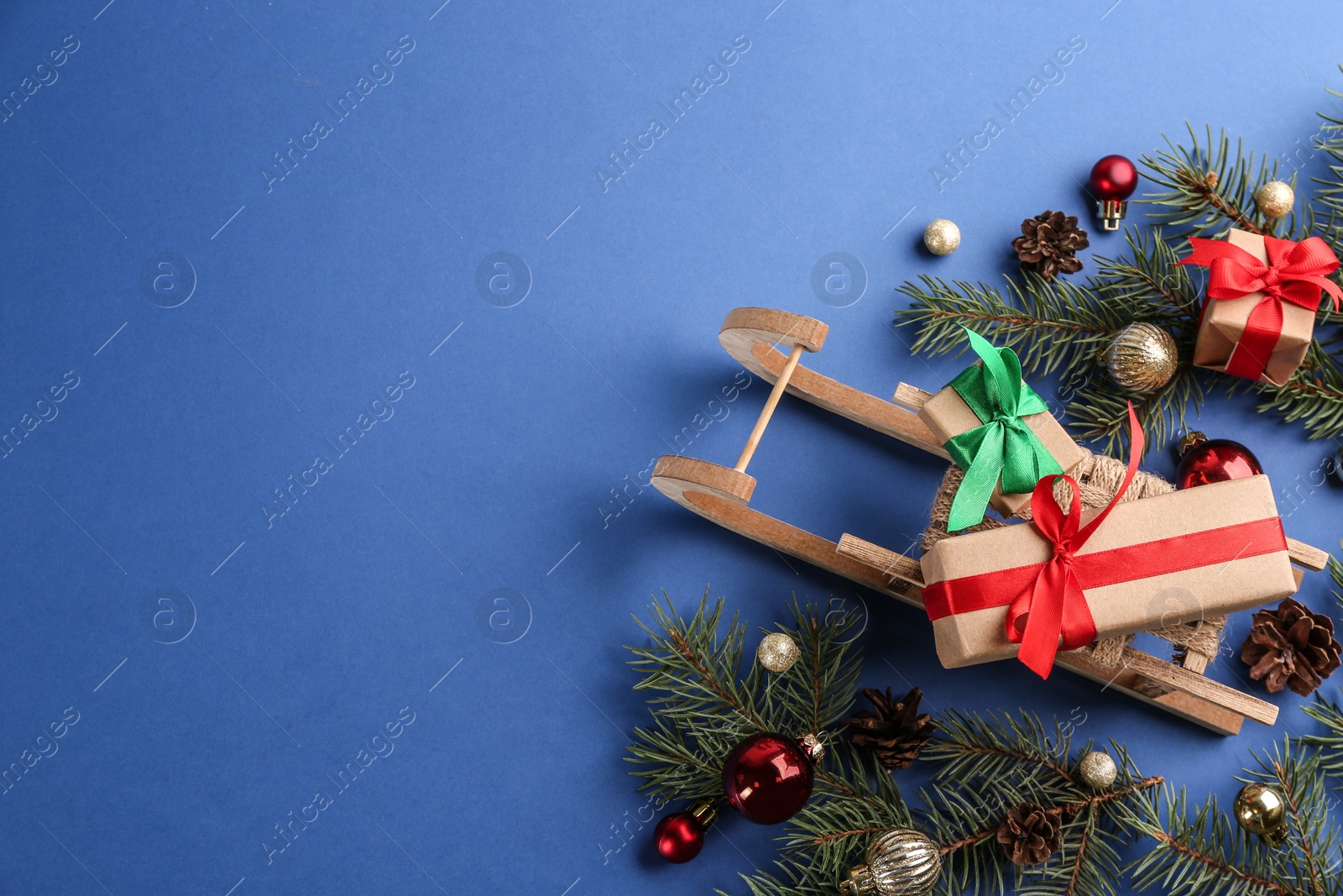 Photo of Beautiful Christmas composition with miniature sleigh on blue background, flat lay. Space for text