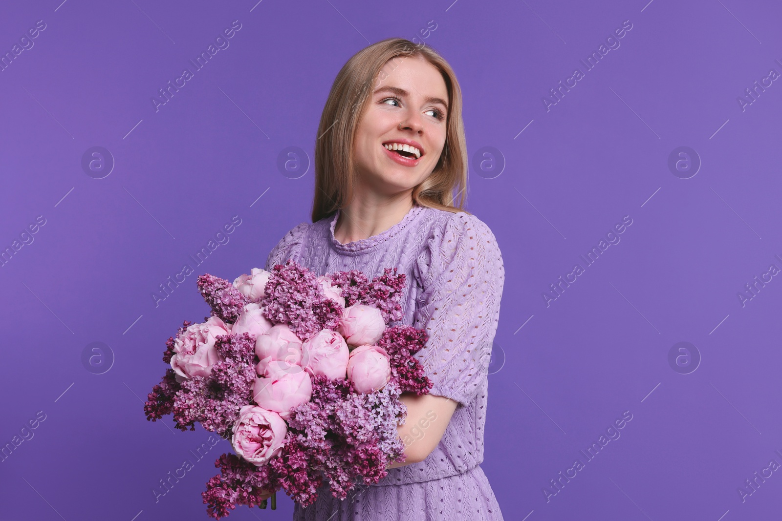 Photo of Beautiful woman with bouquet of spring flowers on purple background