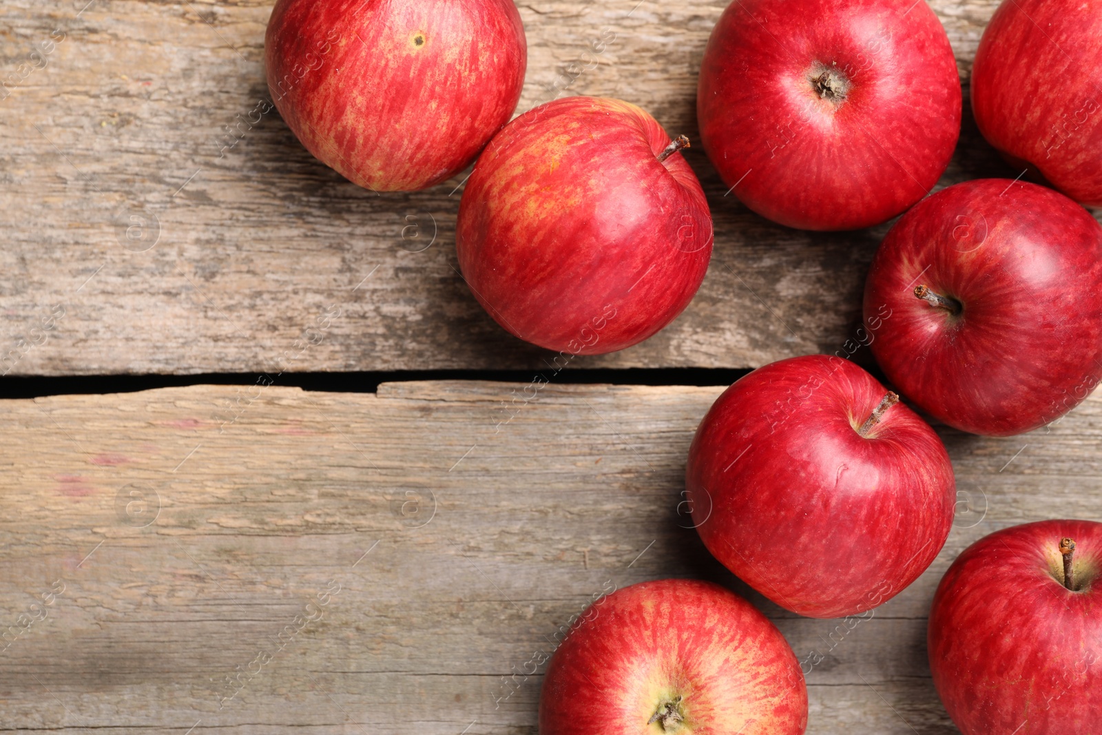 Photo of Fresh red apples on wooden table, flat lay. Space for text