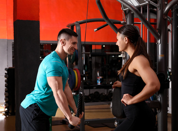 Photo of Trainer and man working out in gym