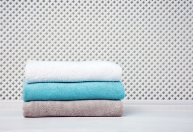 Stack of towels on table against light background