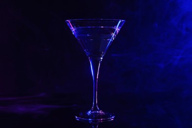Photo of Fresh martini drink on mirror table in neon lights
