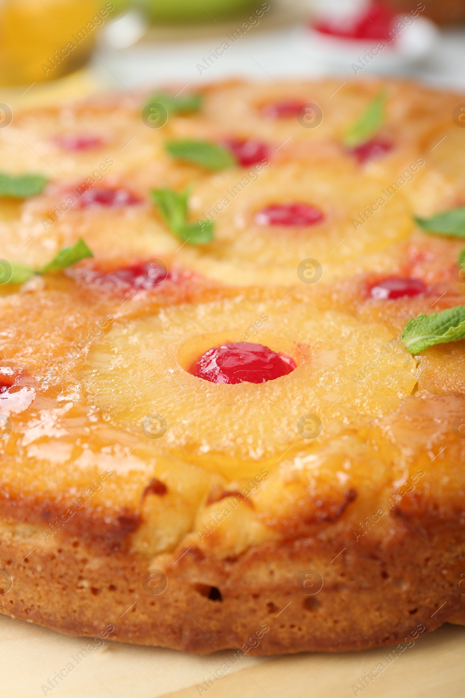 Photo of Tasty pineapple cake with cherries and mint on table, closeup