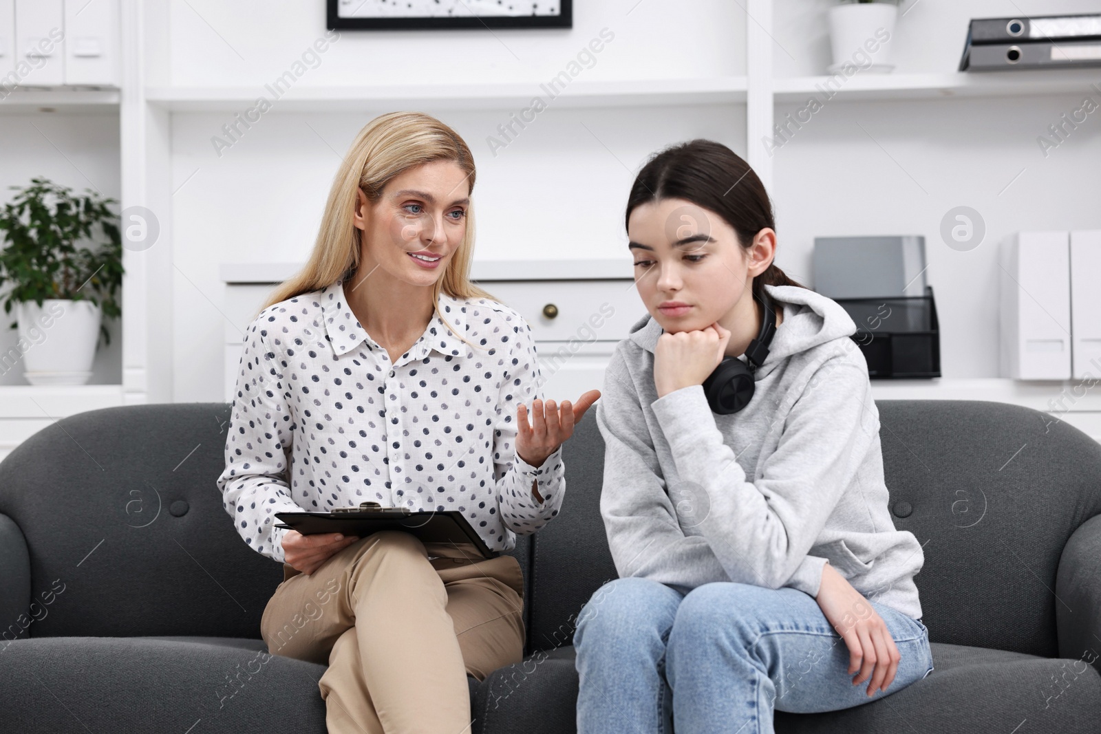 Photo of Psychologist working with teenage girl in office