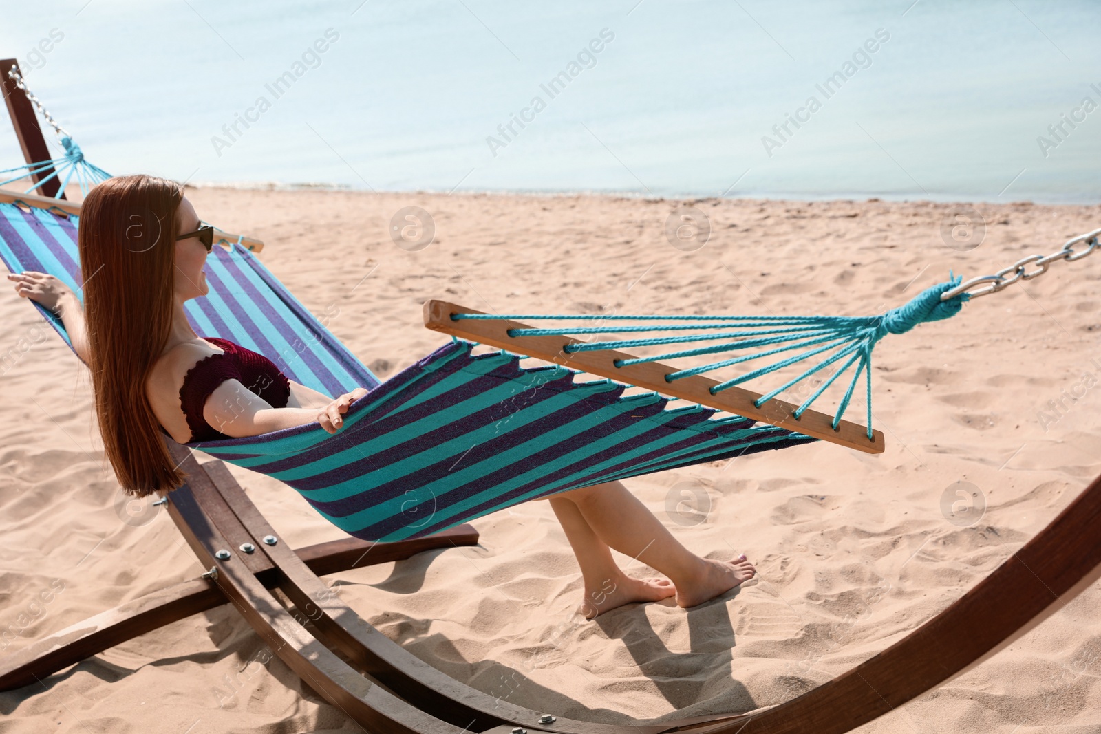 Photo of Young woman relaxing in hammock on beach