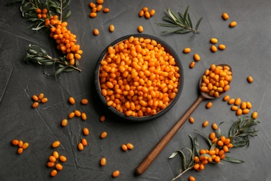 Photo of Fresh ripe sea buckthorn on black table, flat lay