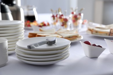 Table with different delicious snacks and dishware indoors. Coffee break