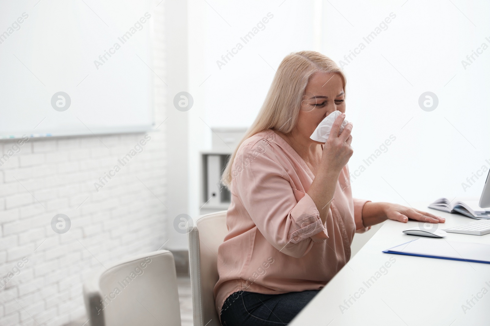 Photo of Sick mature woman at workplace. Dangerous virus