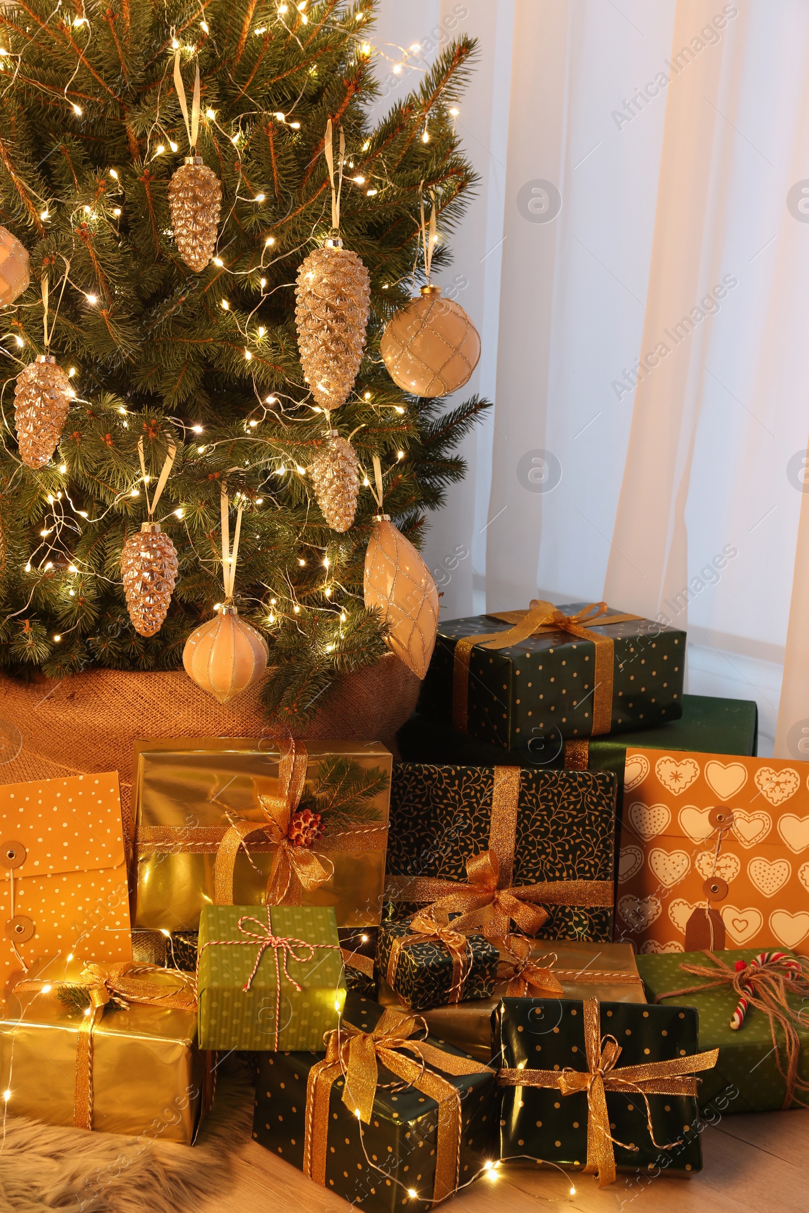 Photo of Many different gifts under Christmas tree indoors