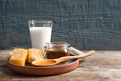 Photo of Beautiful composition with milk and honey on wooden table