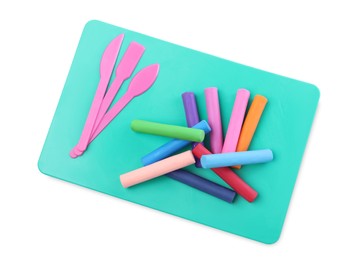 Photo of Many different colorful plasticine pieces and sculpting tools on white background, top view