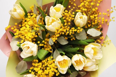 Photo of Bouquet of beautiful spring flowers on light grey background, top view