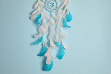 Photo of Beautiful dream catcher hanging on light blue background