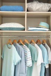 Photo of Stylish clothes, accessories and home stuff in wardrobe closet