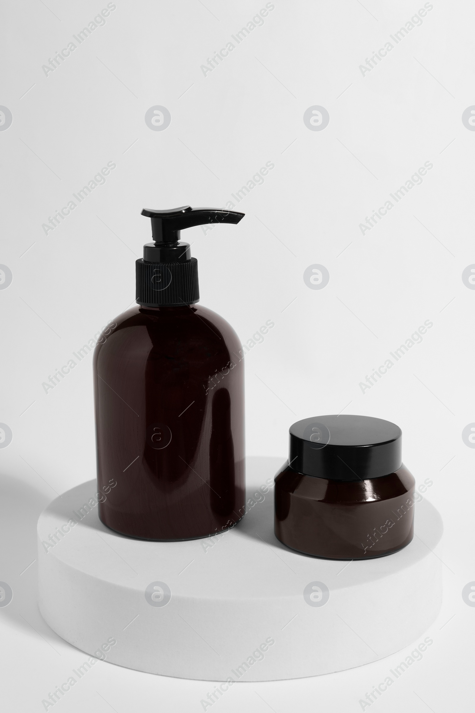 Photo of Bottle and jar with cosmetic products on white background