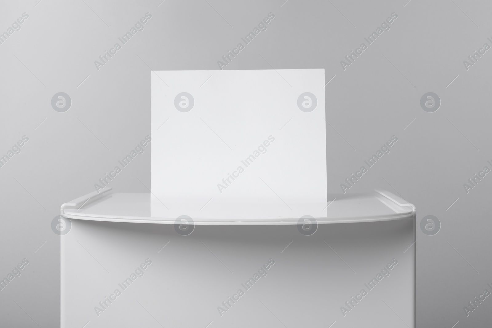 Photo of Ballot box with vote on light grey background, closeup. Election time