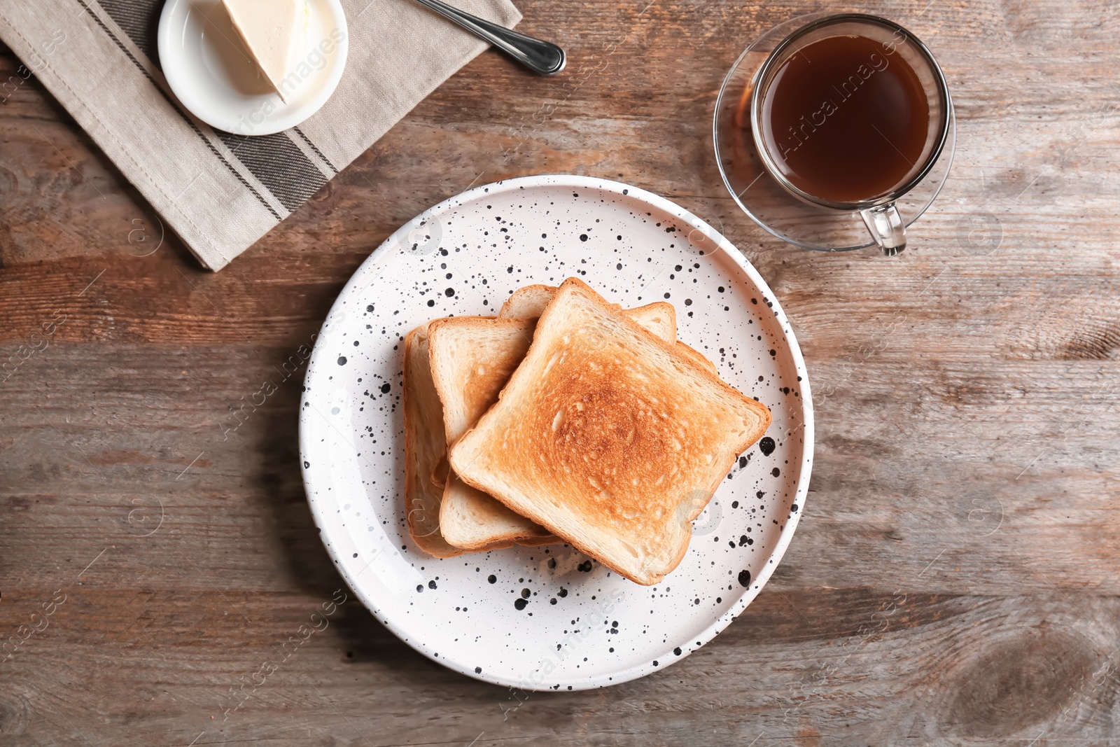 Photo of Plate with toasted bread and cup of coffee on wooden background, top view