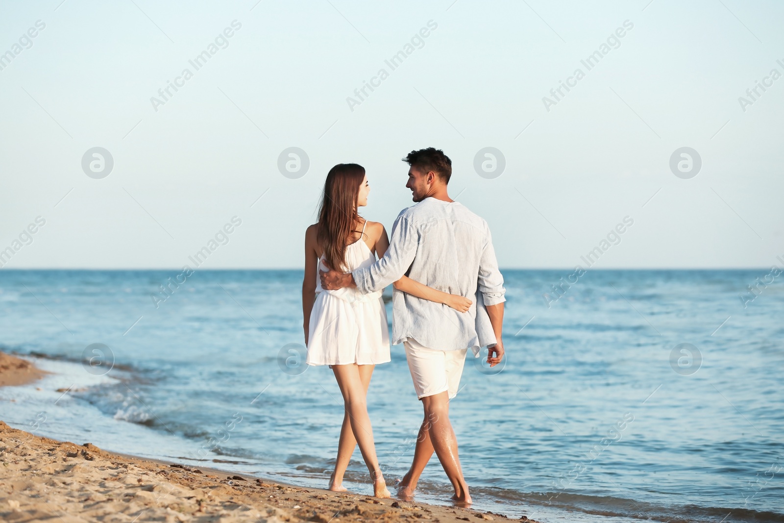 Photo of Happy young couple walking together on beach