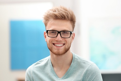 Photo of Portrait of handsome young man with glasses in room