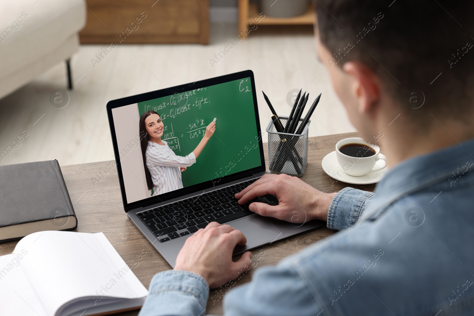 Image of E-learning. Young man having online lesson with teacher via laptop at home