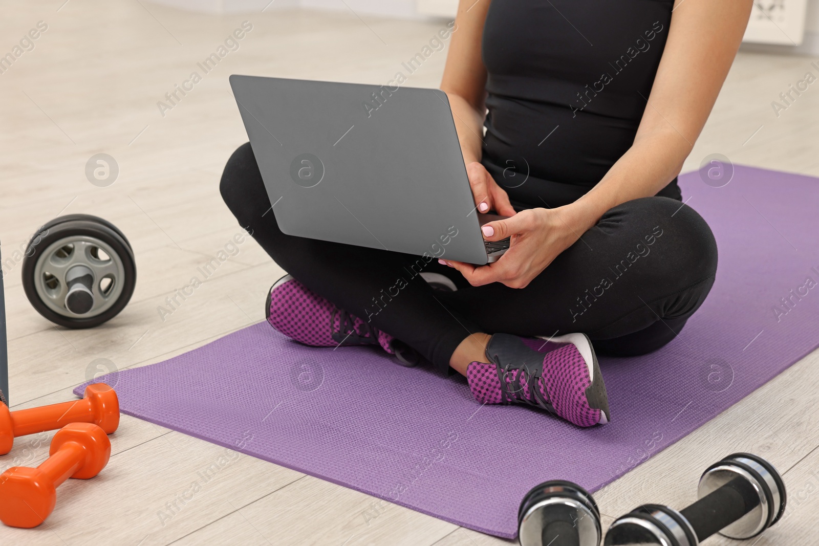 Photo of Online fitness trainer. Woman watching tutorial on laptop indoors, closeup