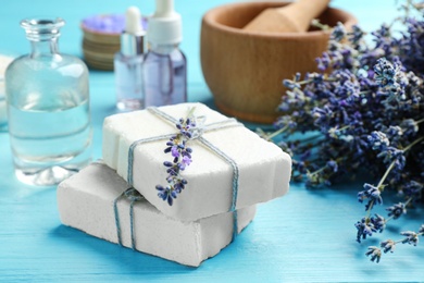Hand made soap bars with lavender flowers on light blue wooden table