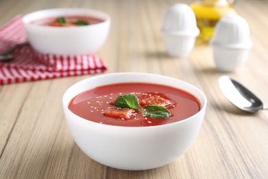 Bowl with fresh homemade tomato soup on wooden table