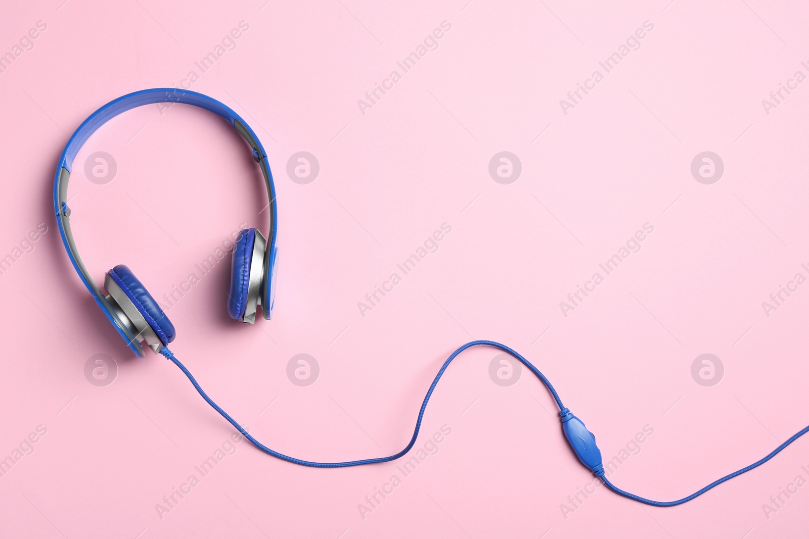 Photo of Stylish headphones on color background, top view. Space for text