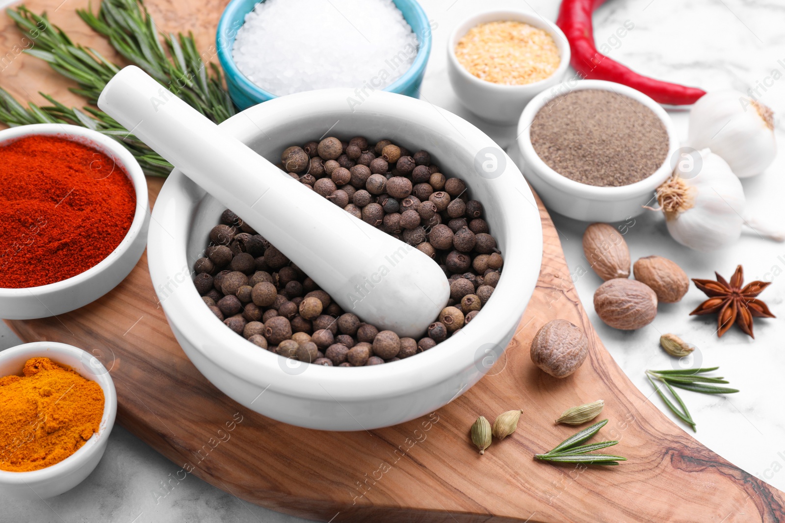 Photo of Mortar and spices on white marble table, closeup