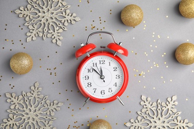 Photo of Flat lay composition with alarm clock and decorations on grey background. Christmas countdown