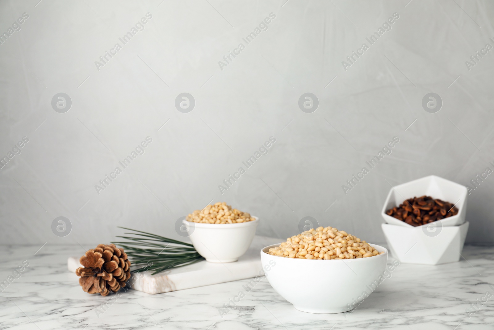 Photo of Bowl with pine nuts on table. Space for text