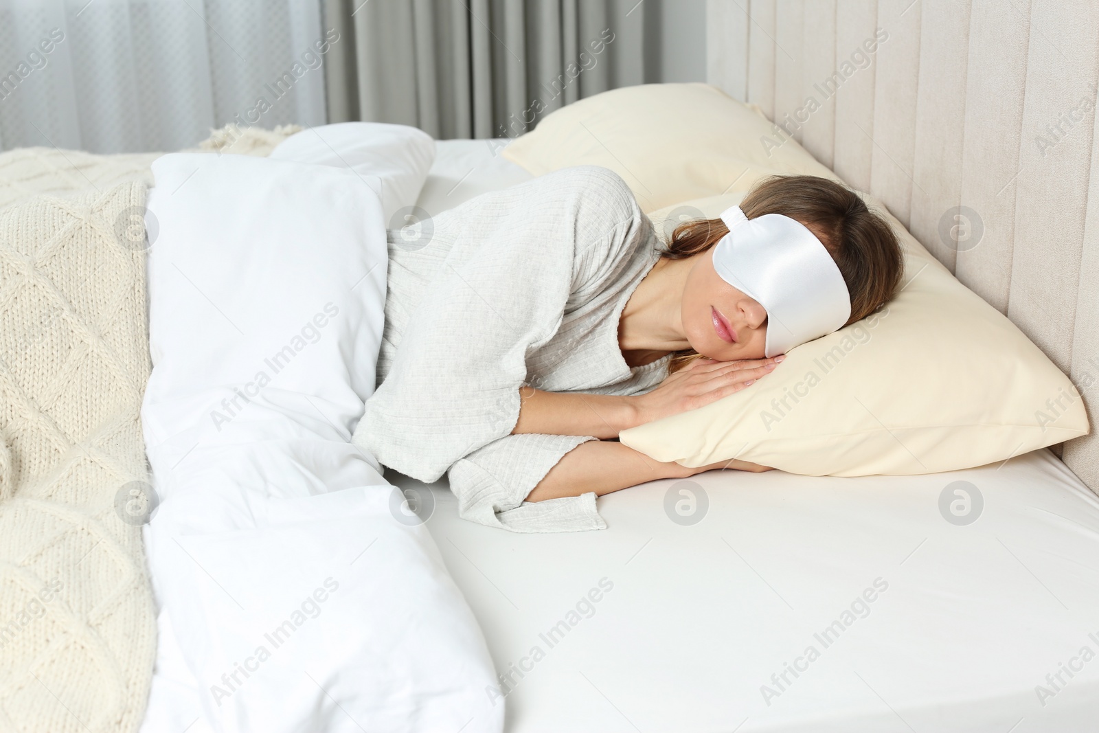 Photo of Woman with sleep mask in bed at home
