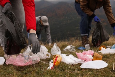 People with trash bags collecting garbage in nature, closeup