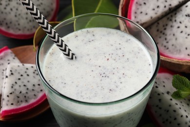 Photo of Delicious pitahaya smoothie and fresh fruits on table, closeup