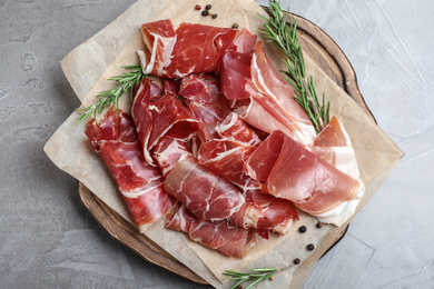 Photo of Tasty prosciutto on grey table, top view