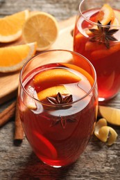 Photo of Aromatic punch drink and ingredients on wooden table