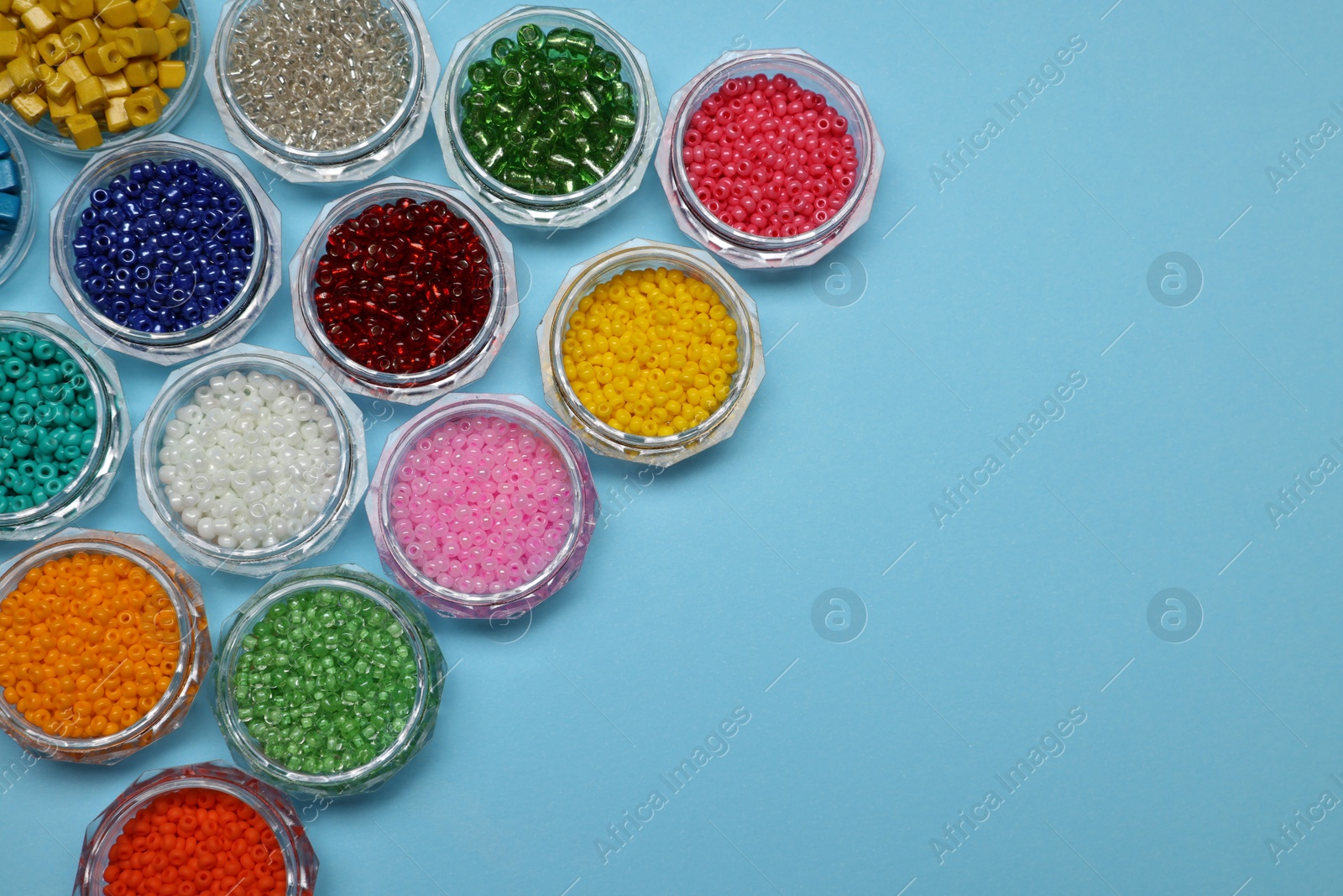 Photo of Flat lay composition with different colorful beads on light blue background, space for text