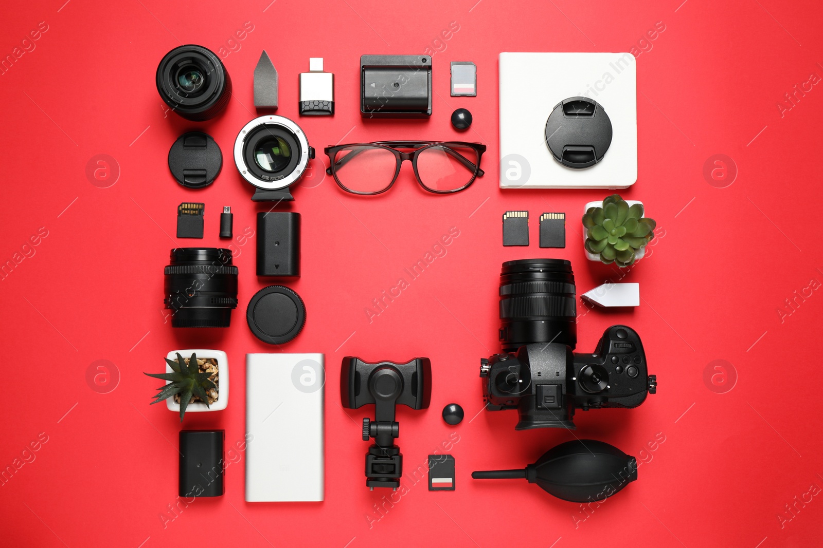 Photo of Flat lay composition with camera and video production equipment on red background. Space for text