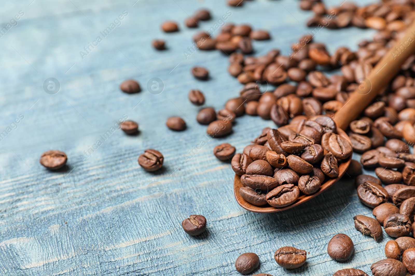 Photo of Spoon and coffee beans on wooden table