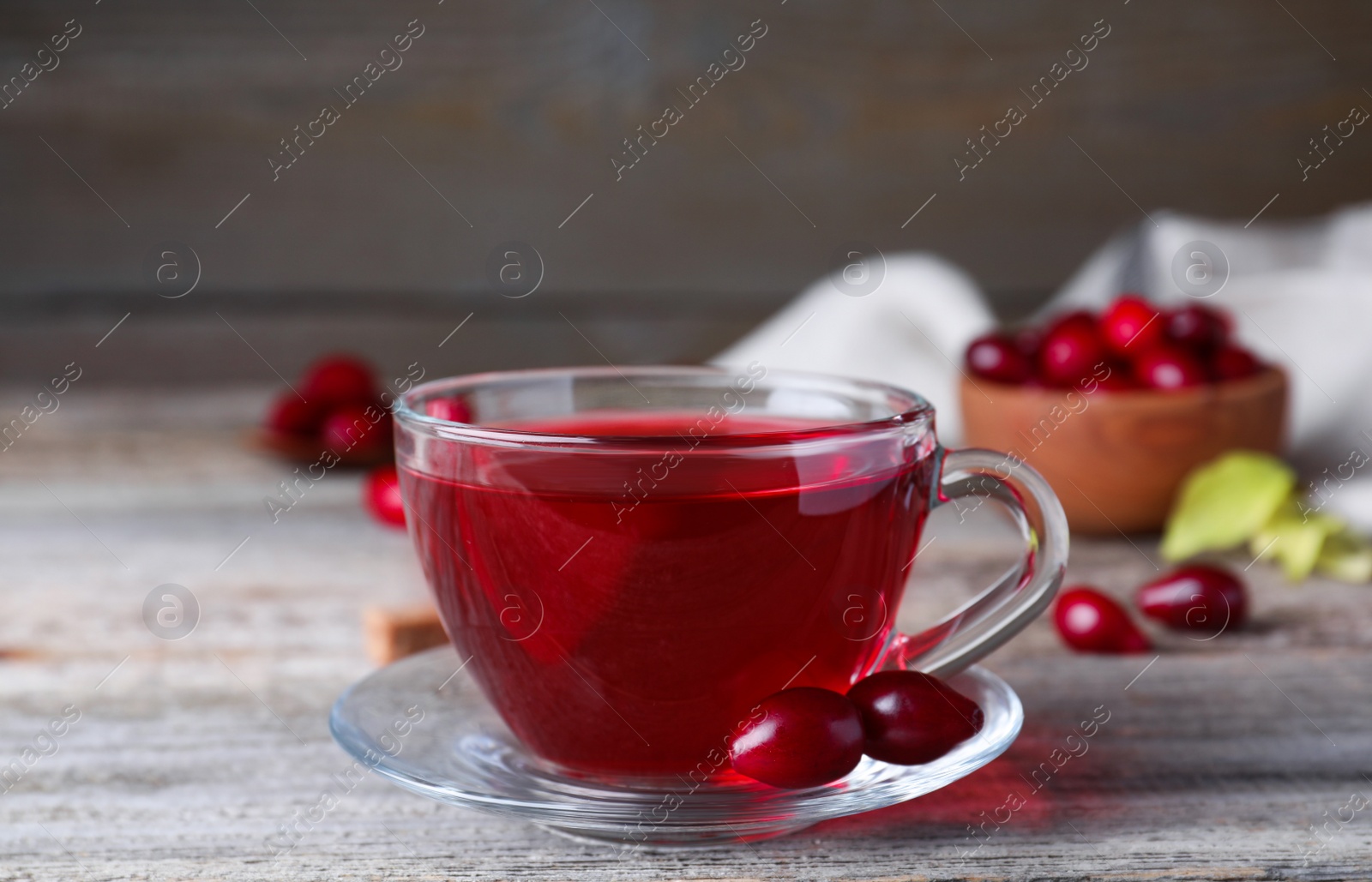 Photo of Fresh dogwood tea and berries on wooden table