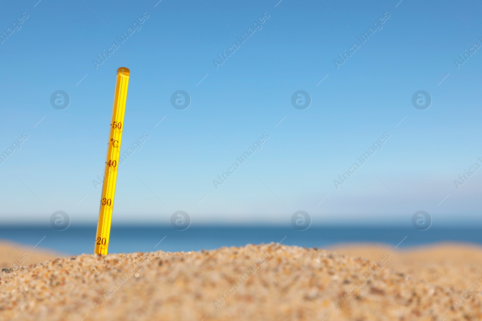 Photo of Weather thermometer in sand near sea, space for text