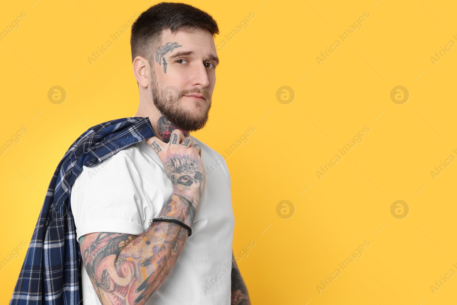 Photo of Portrait of handsome hipster man on yellow background. Space for text