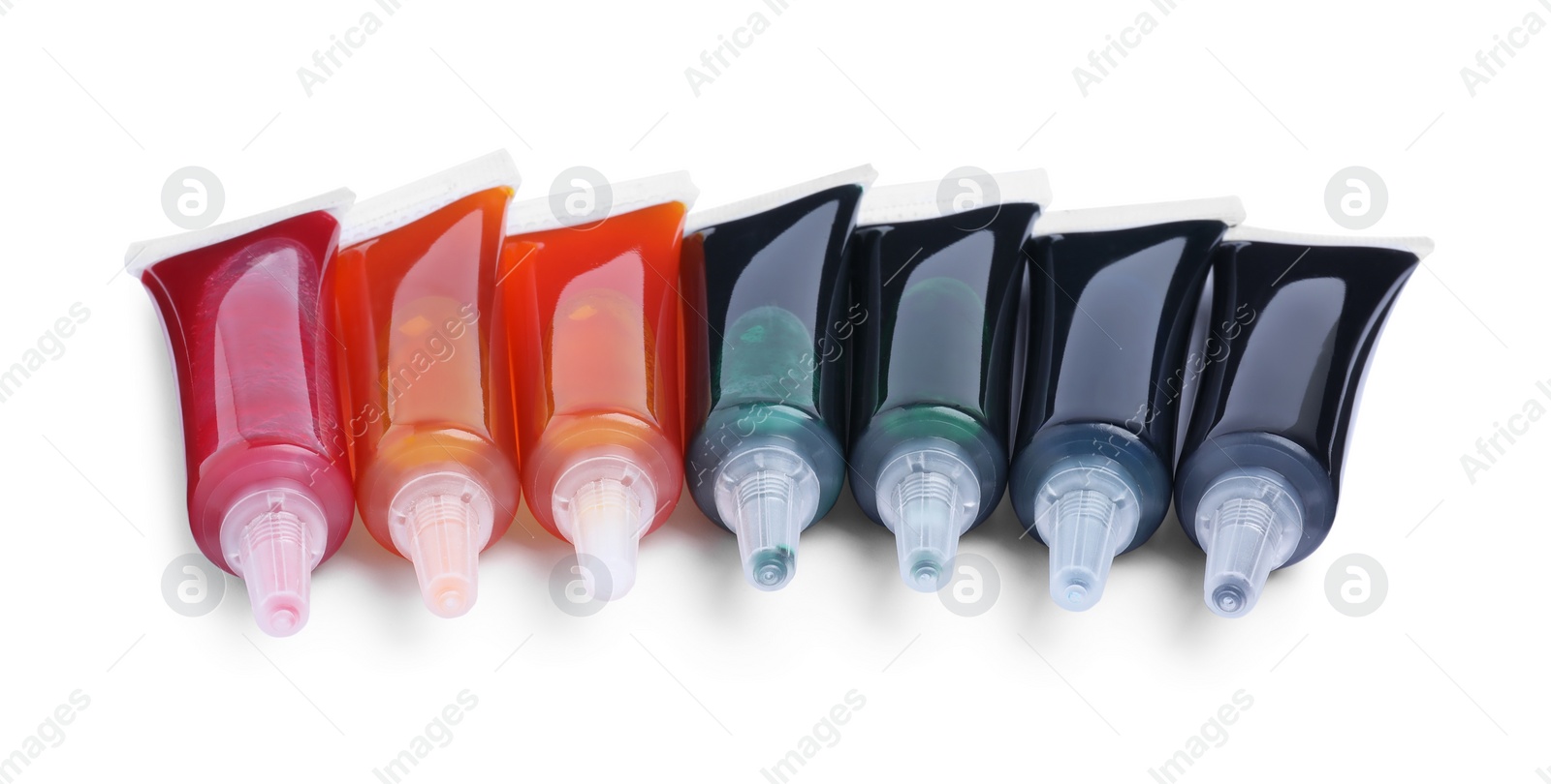 Photo of Tubes with different food coloring on white background