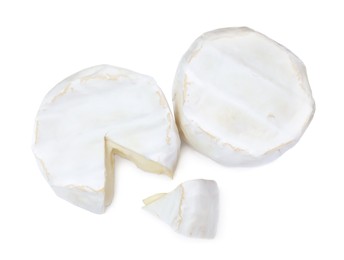 Tasty cut and whole brie cheeses on white background, top view